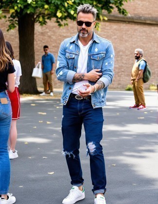 Light Blue Denim Jacket · White Long Sleeve Shirt · Navy Ripped Jeans · White and Green Leather Low Top Sneakers · Black Studded Leather Belt · Black Sunglasses