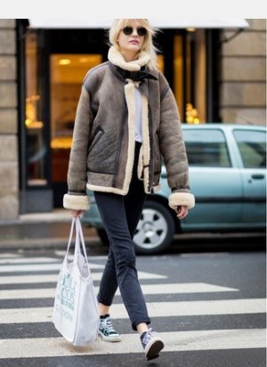Brown Shearling Jacket · White Crew-neck T-shirt · Black Jeans · Black and White Canvas Low Top Sneakers · White Canvas Tote Bag · Black Sunglasses