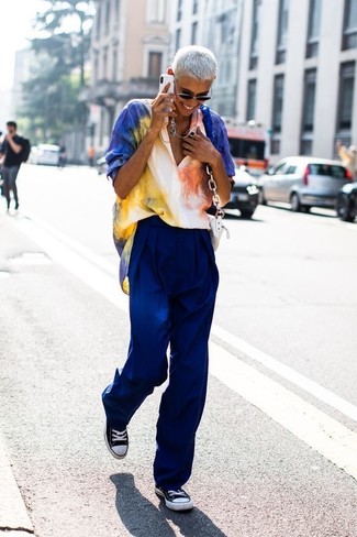 Multi colored Tie-Dye Short Sleeve Blouse · Blue Wide Leg Pants · Black and White Canvas Low Top Sneakers · White Leather Crossbody Bag · Black Sunglasses · Silver Necklace
